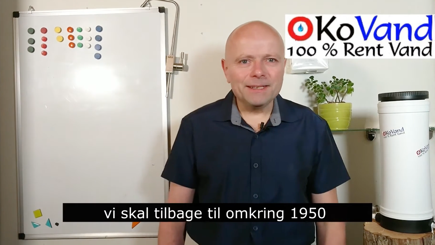 Mand i mørkeblå skjorte foran whiteboard om vandkvalitet