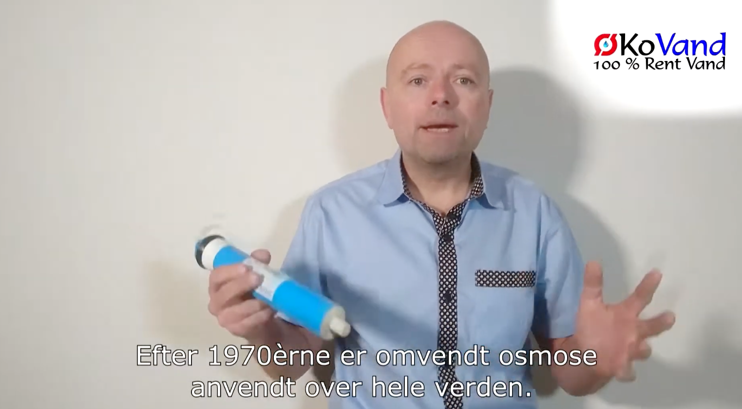 Mand holder vandfilter og forklarer om omvendt osmose