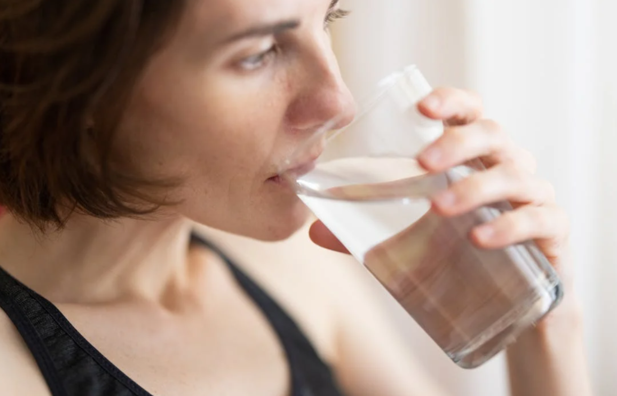 Kvinde drikker rent vand fra glas